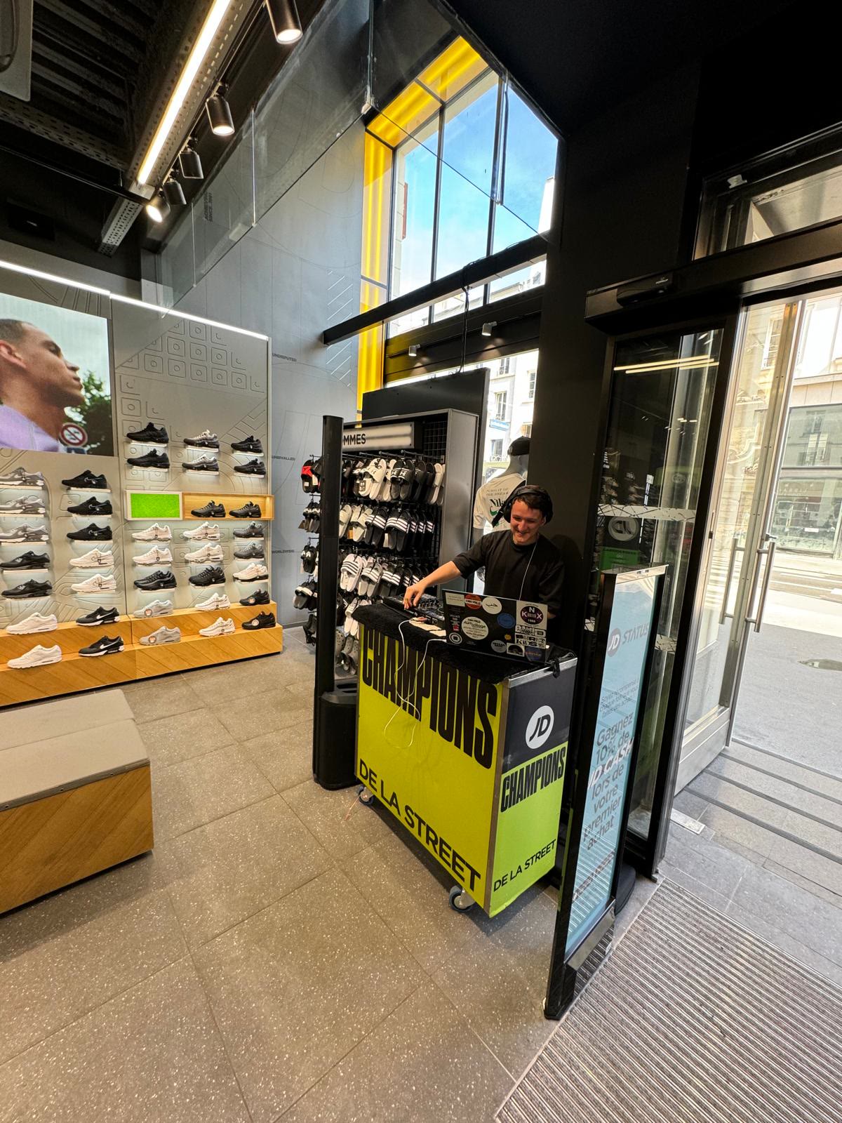 Activation de marque JD Sports en boutique : habillage, écran et platine installés au milieu du magasin